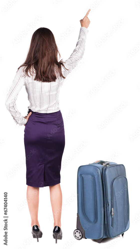 Back view of young brunette woman traveling with suitcas and poi Back view of young brunette woman traveling with suitcas and poi