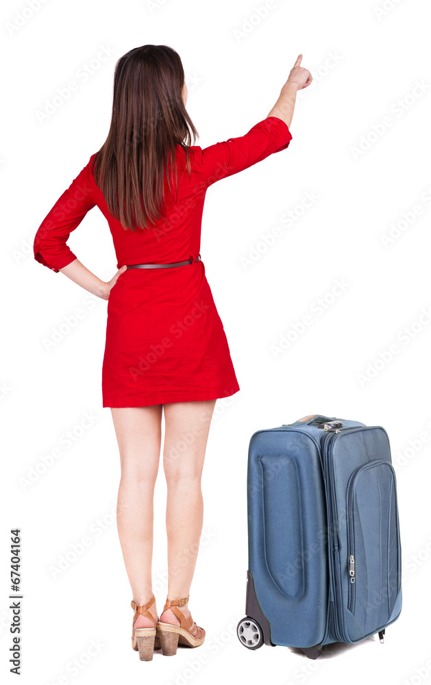 Back view of young brunette woman traveling with suitcas and poi Back view of young brunette woman traveling with suitcas and poi