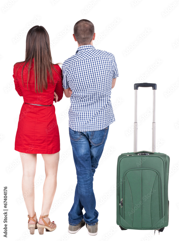 Back view of young couple traveling with suitcas . Back view of young couple traveling with suitcas .