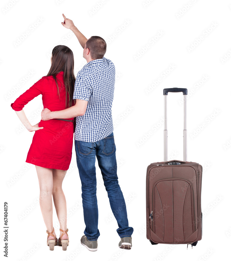 young couple traveling with suitcas and pointing at wal Back vie young couple traveling with suitcas and pointing at wal Back vie