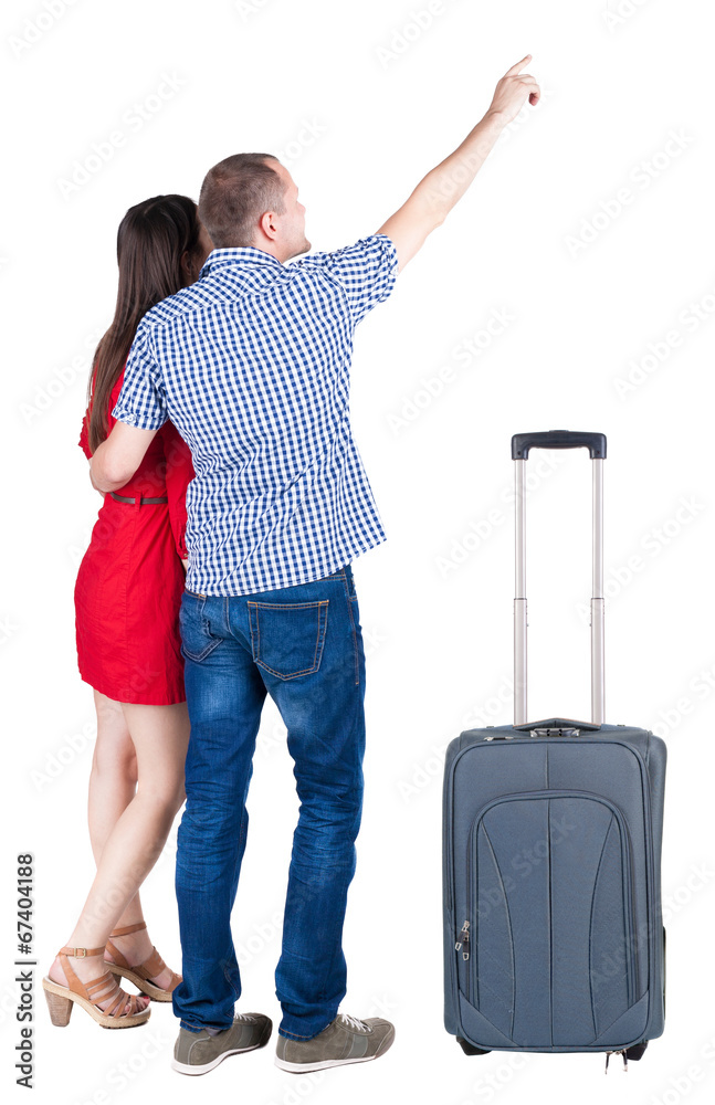 young couple traveling with suitcas and pointing at wal Back vie young couple traveling with suitcas and pointing at wal Back vie