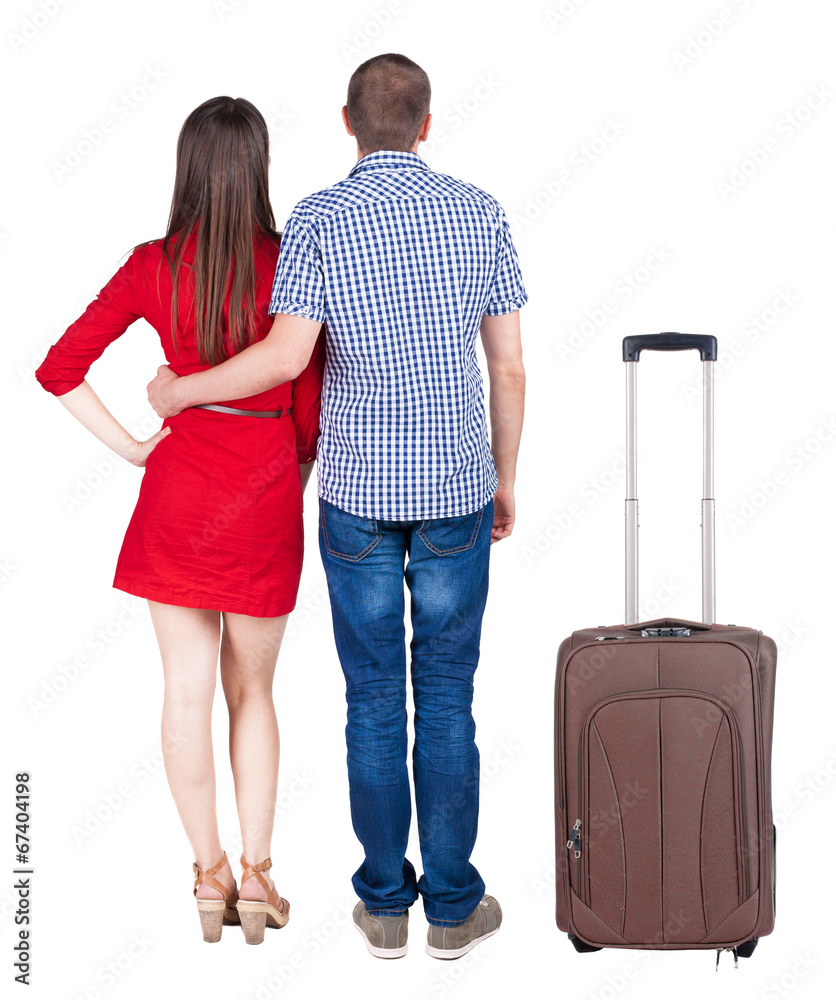 Back view of young couple traveling with suitcas . Back view of young couple traveling with suitcas .