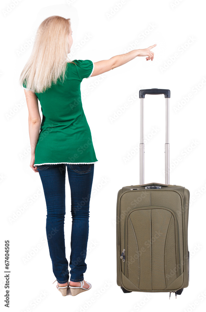 Back view of young brunette woman traveling with suitcas and poi Back view of young brunette woman traveling with suitcas and poi