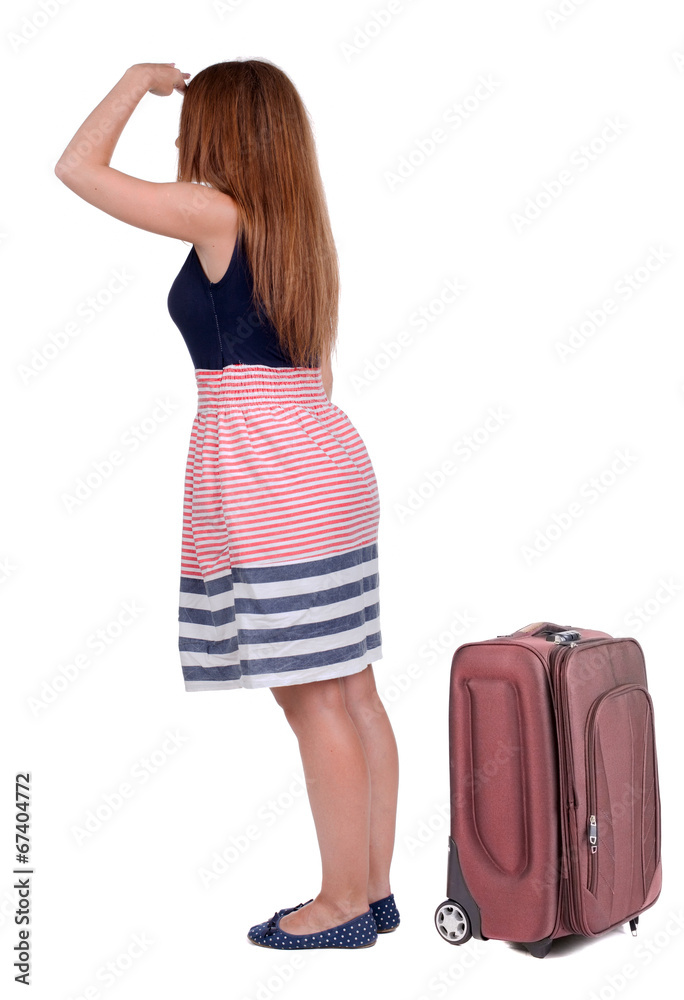 back view of young beautiful redhead woman traveling with suitca back view of young beautiful redhead woman traveling with suitca