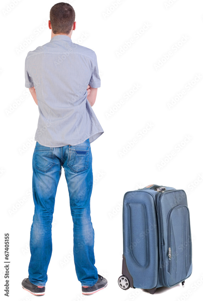 Back view of young man traveling with suitcas. Back view of young man traveling with suitcas.