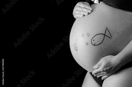 belly of a pregnant woman with a fish on it
