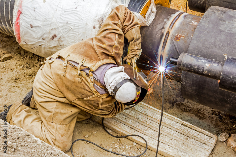 Metalworker working on a pipeline Metalworker working on a pipeline