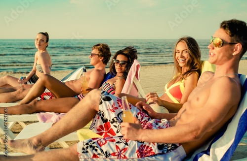 Group of multi ethnic friends sunbathing on  a beach © Nejron Photo