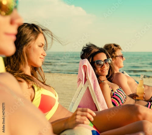 Group of multi ethnic friends sunbathing on a beach