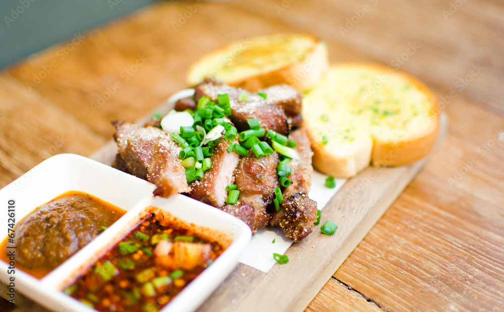 Slice Grilled pork with thai chilli sauce and garlic bread serve Slice Grilled pork with thai chilli sauce and garlic bread serve