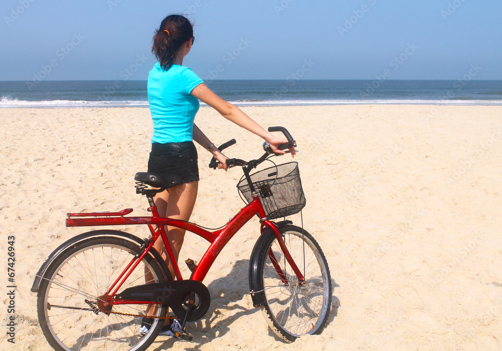 beautiful girl on a bicycle on the beach
