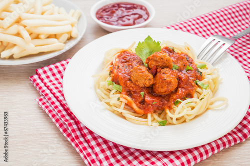 Spaghetti with meatballs in tomato sauce and french fries