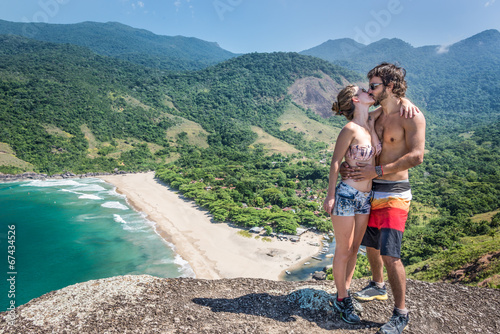 Beautiful couple kissing at a stone cliff, Brazil tropical islan