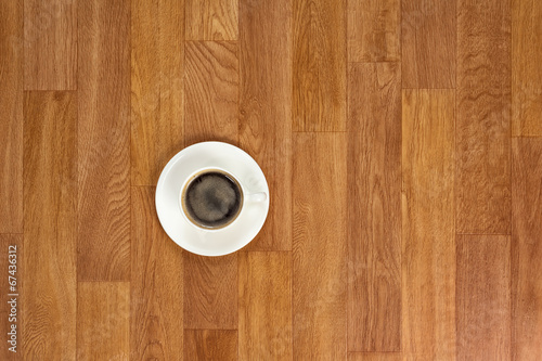 White cup of coffee on wooden table.