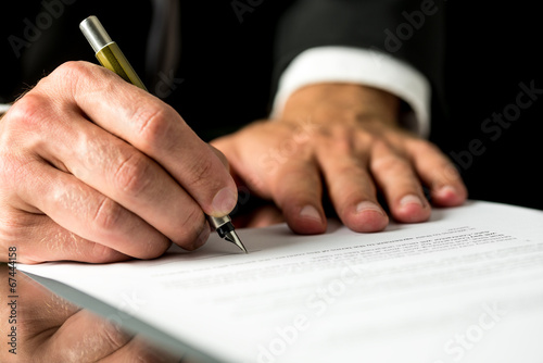 Man signing a typed document photo
