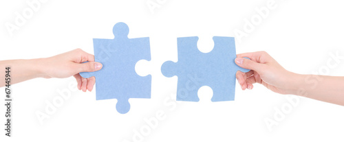 two puzzle pieces in woman hands isolated on white photo