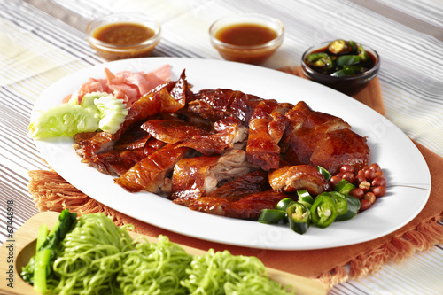 close up chinese roasted duck and green noodle in white dish