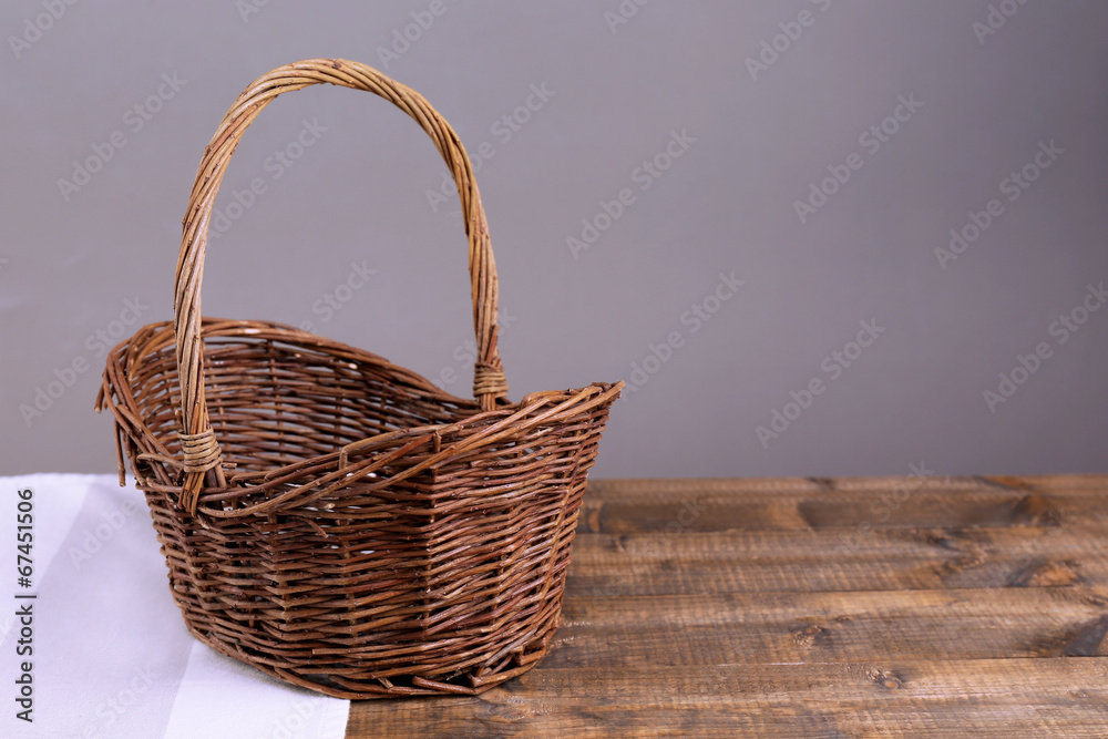 Empty wicker basket on wooden table, on dark background Empty wicker basket on wooden table, on dark background