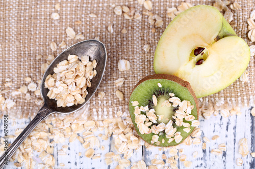 Apple, kiwi fruit with oatmeal and vintage spoon