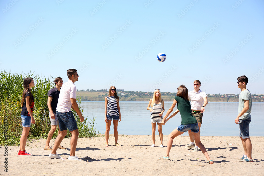 © Africa Studio - Group of friends playing volleyball at beach