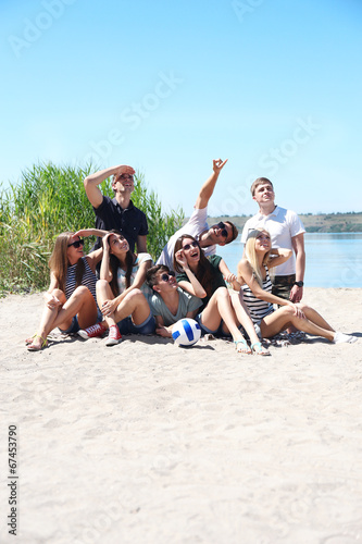 Group of friends with ball at beach © Africa Studio