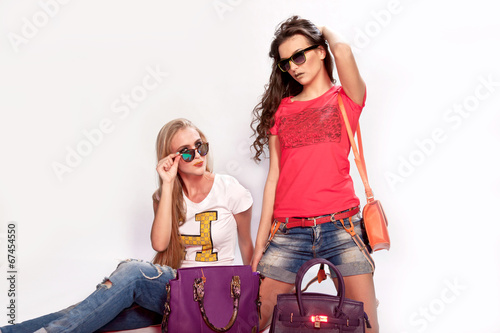 Две красивые девушки с сумками и солнечными очками
