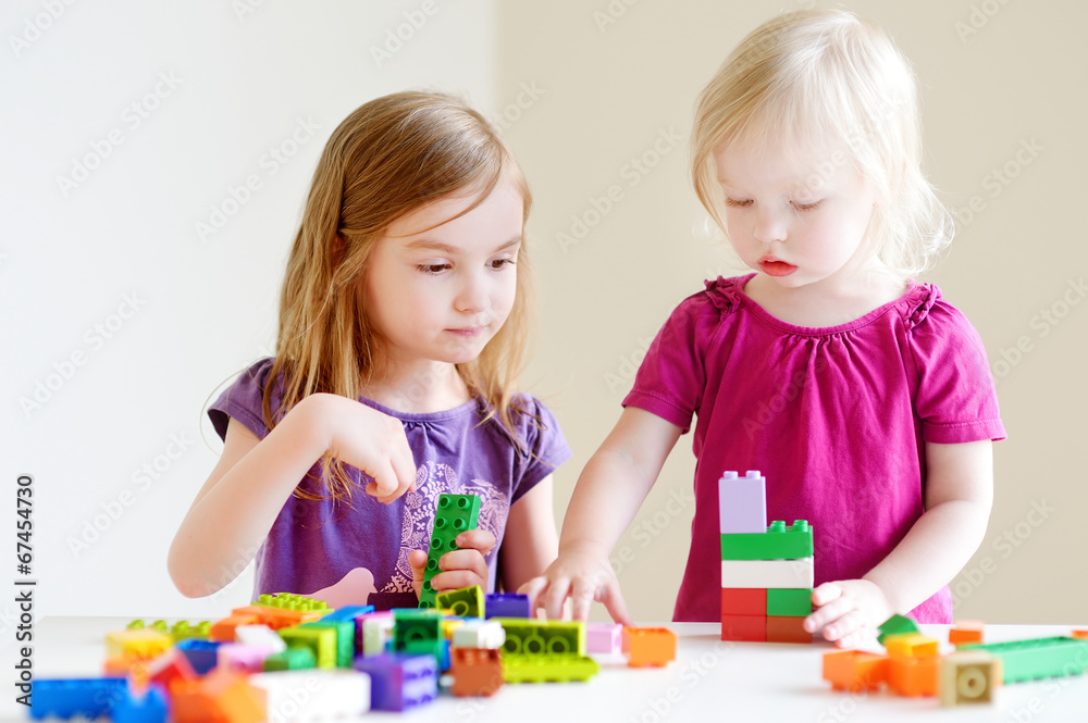 Two little sisters playing with colorful blocks Two little sisters playing with colorful blocks