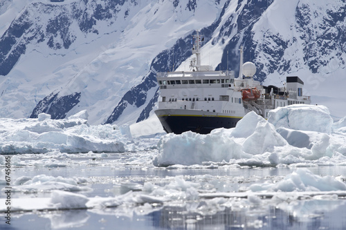 big blue tourist ship in the ice in the background of the Antarc