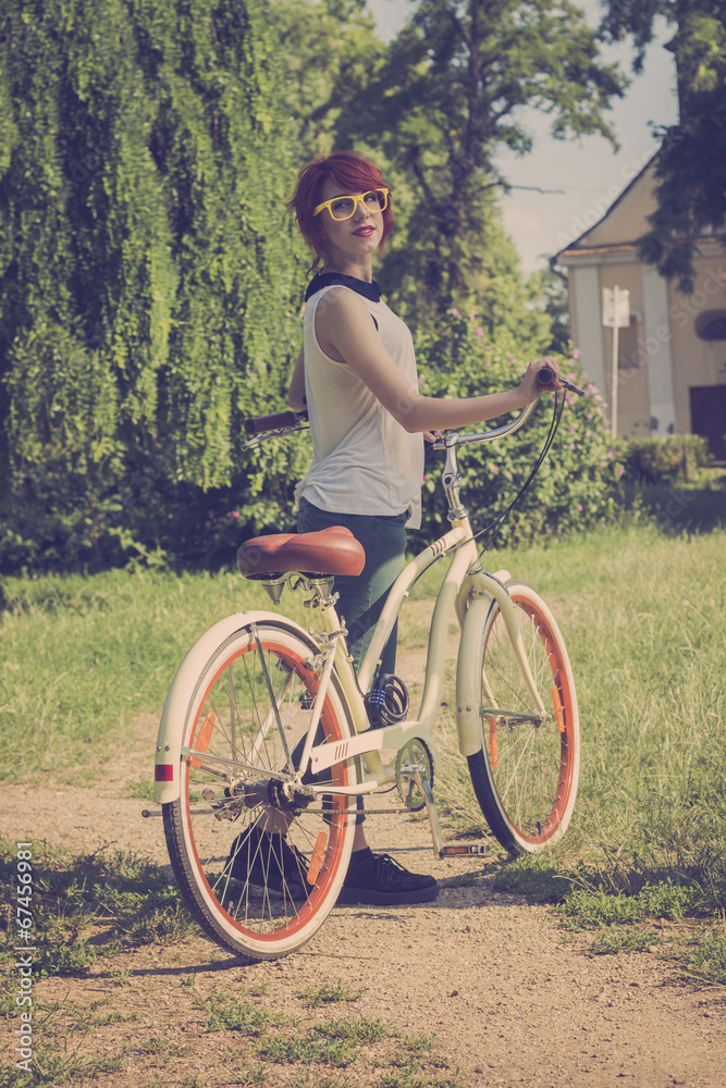 Obraz premium Hipster girl with her vintage bicycle, enjoying beautiful sunny
