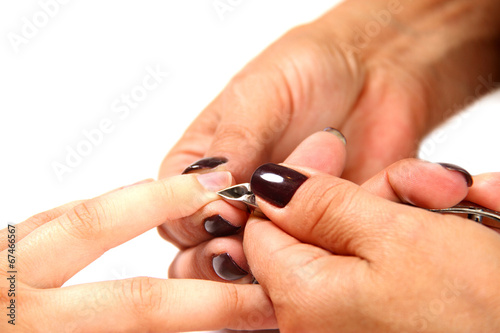 cutting the cuticle with cutter during manicure process