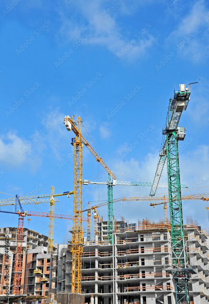 Crane and building construction site against blue sky Crane and building construction site against blue sky