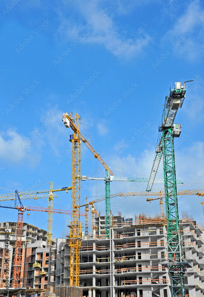 Crane and building construction site against blue sky