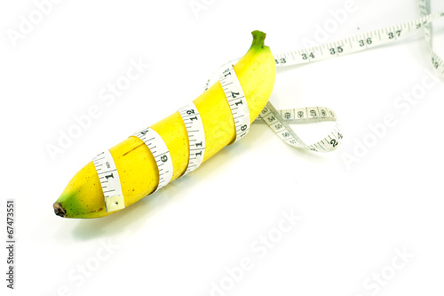 Large banana and measuring tape on a white background
