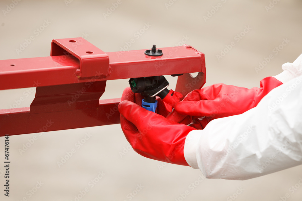 Naklejka premium Tractor spray nozzle adjustment
