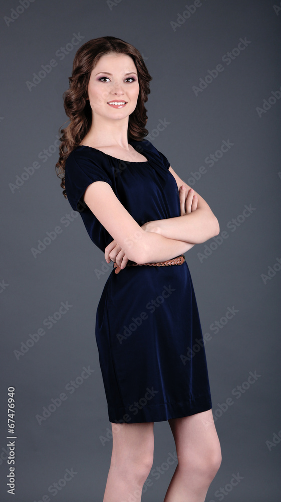 Beautiful young girl in dress on grey background Beautiful young girl in dress on grey background