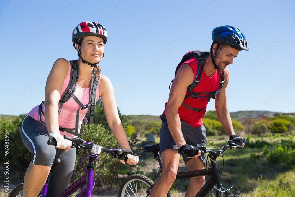 Active couple cycling in the countryside Active couple cycling in the countryside