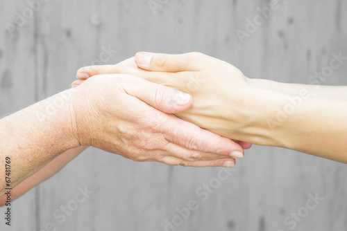 hands of a young girl in the hands of an old woman