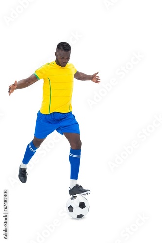 Football player in yellow kicking ball