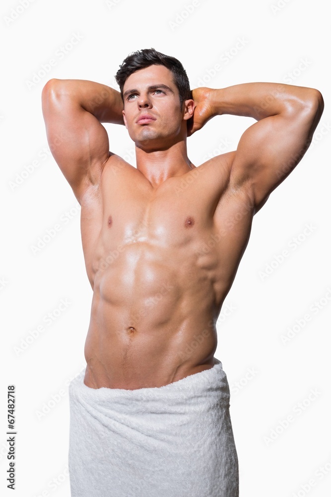 Shirtless muscular man wrapped in white towel