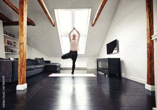 Young caucasian woman practicing yoga exercise at home