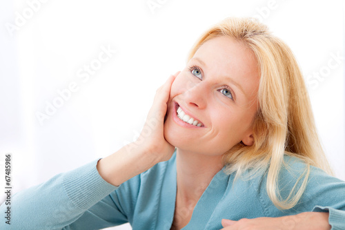 Attractive blonde pensive  woman in a sofa