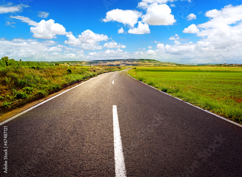 Concept of straight path to success. Asphalt road over blue sky