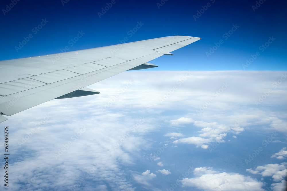 Fototapeta premium Wing of the plane on blue sky background and snowy mountains,