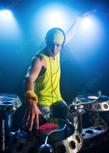 dj in a bright shirt plays on vinyl