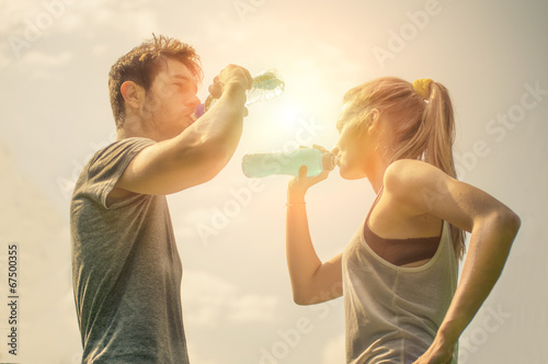Couple drink water after running