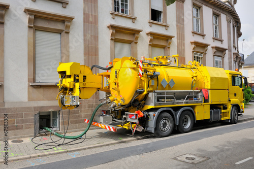 Sewage truck working in urban city environment photo