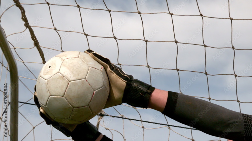 Goalkeeper in red saving a goal during a game