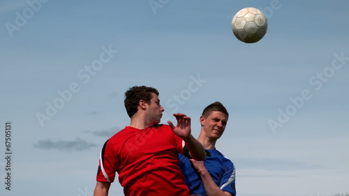 Football players jumping up and tackling for the ball