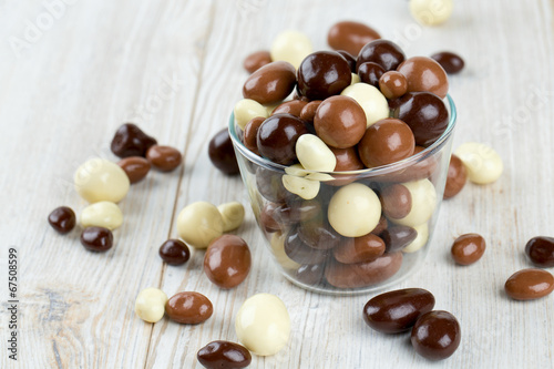 chocolate covered nuts and raisins on wooden surface