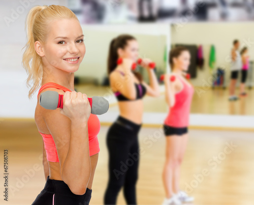 smiling beautiful sporty woman with dumbbell